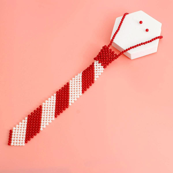 Red and white pearl stripe tie choker necklace with matching earrings on a pink background.