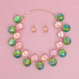 Women's pink and green iridescent bubble ball bead necklace set with matching earrings, featuring gold spacers.